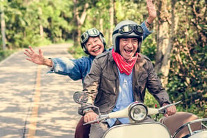 Retirees enjoying retirement while riding a moped because they have a reverse mortgage